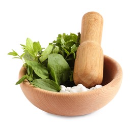 Photo of Mortar with fresh green herbs and pills on white background