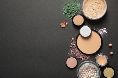 Photo of Flat lay composition with various makeup face powders on dark background. Space for text