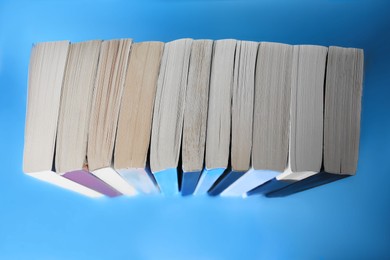 Photo of Collection of books on light blue background, above view