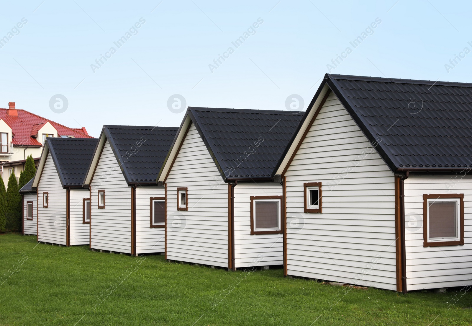 Photo of Beautiful wooden beach houses and green lawn outdoors