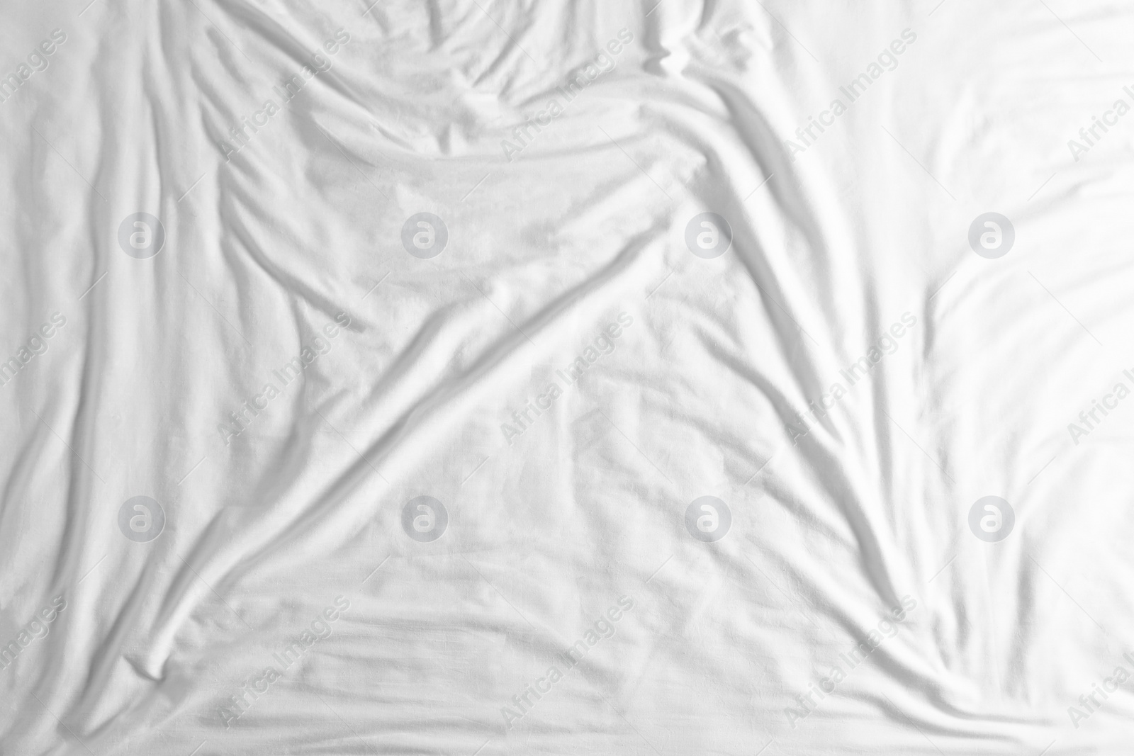 Photo of Crumpled white fabric as background, top view