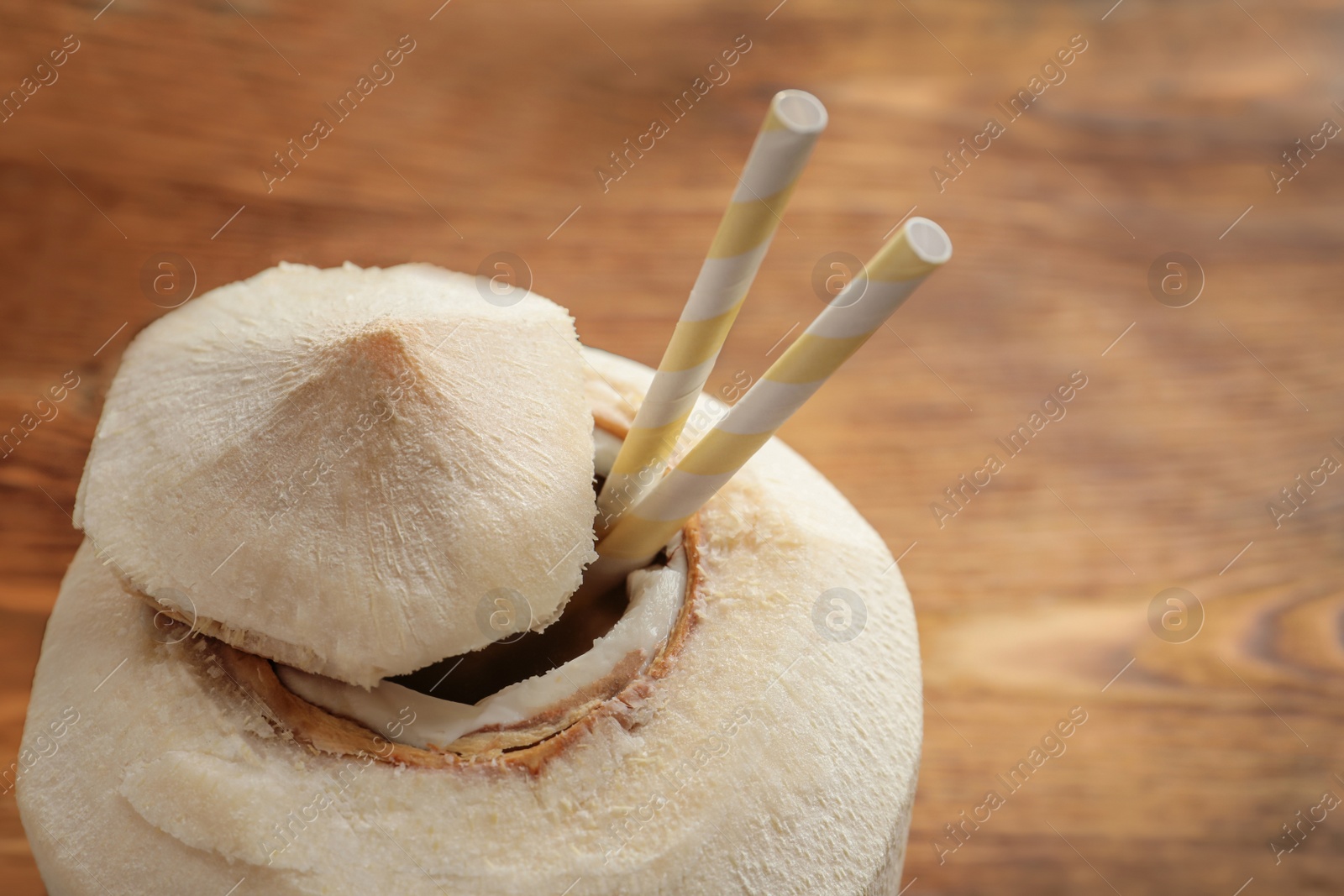 Photo of Fresh coconut drink in nut on wooden background