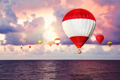 Bright hot air balloons flying over sea