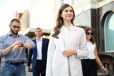 Photo of Different people walking on modern city street