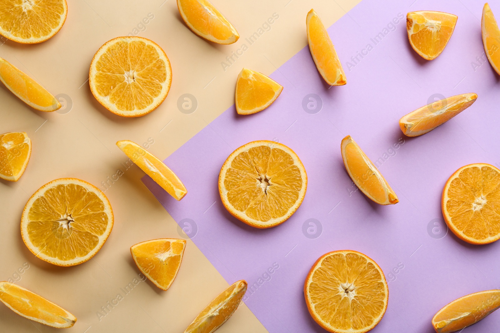 Photo of Slices of delicious oranges on color background, flat lay