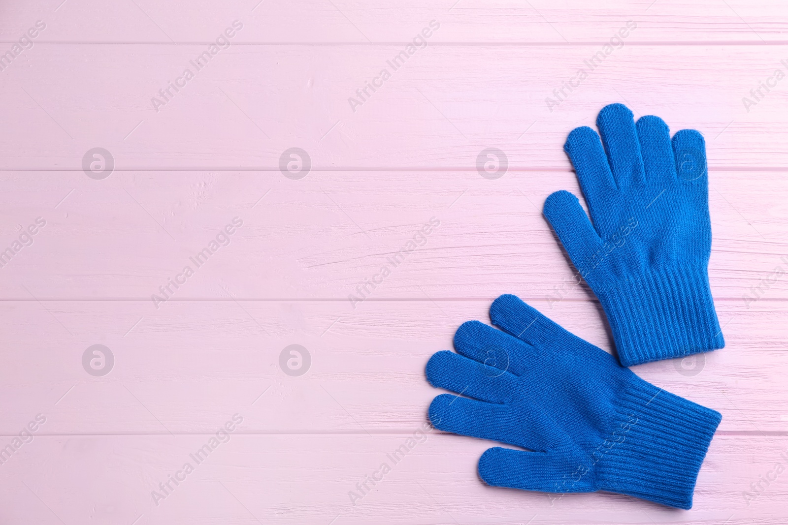 Photo of Stylish gloves on pink wooden background, flat lay. Space for text