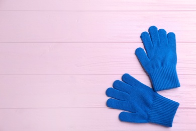 Stylish gloves on pink wooden background, flat lay. Space for text