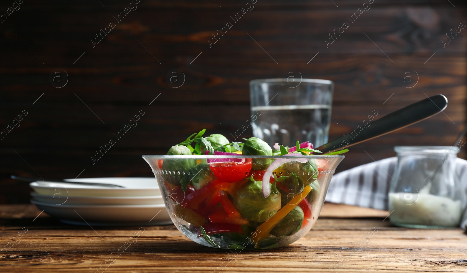 Photo of Tasty salad with Brussels sprouts served on wooden table