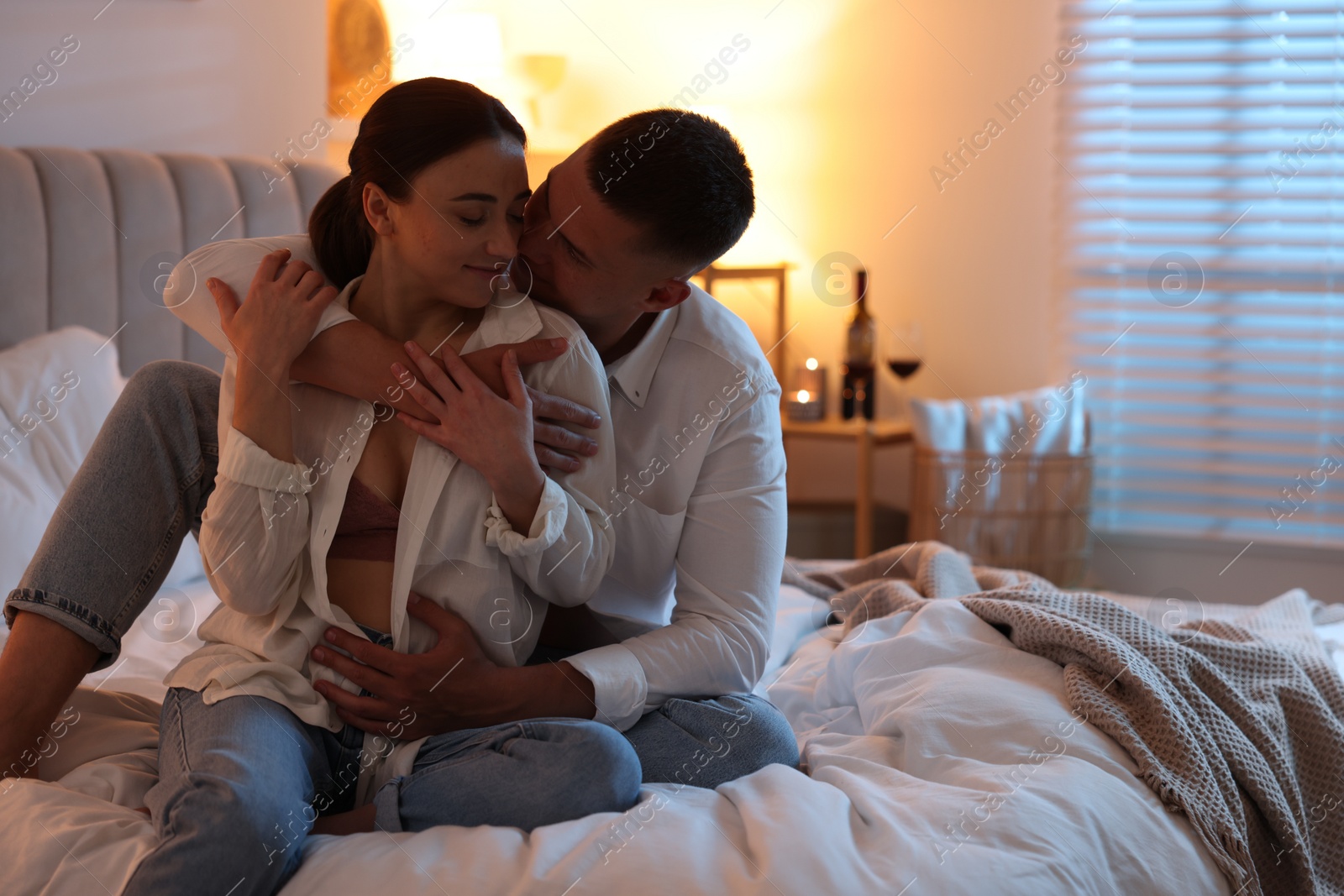 Photo of Affectionate couple enjoying each other on bed at night