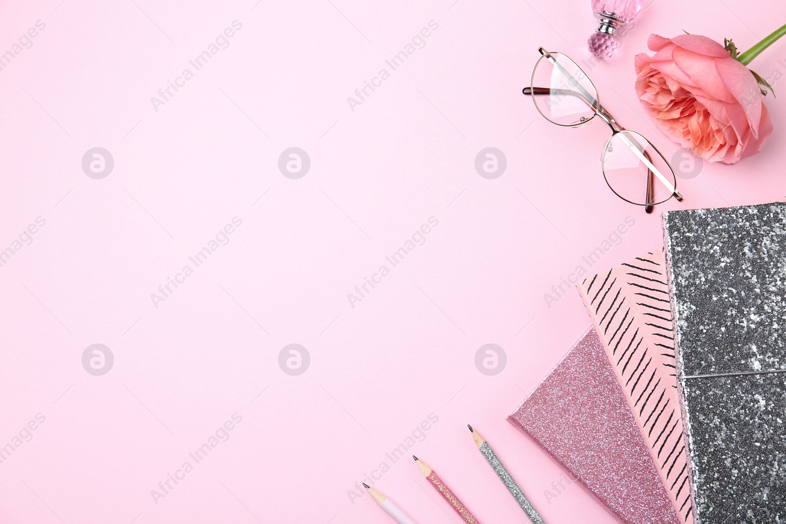 Photo of Flat lay composition with notebooks and flower on pink background. Space for text