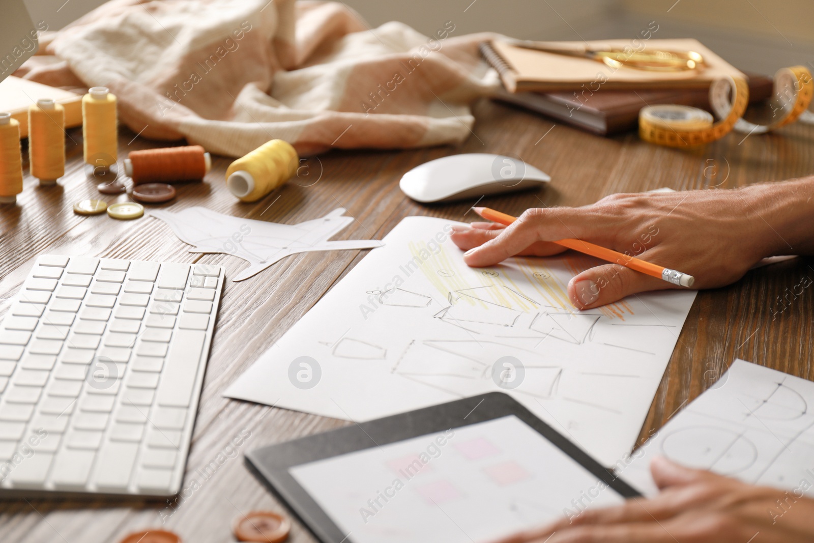 Photo of Male fashion designer working at wooden table, closeup