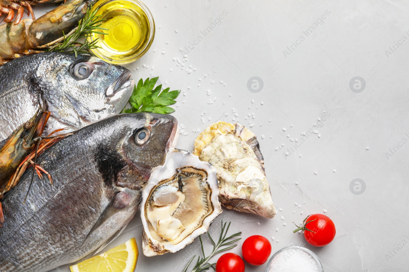 Photo of Flat lay composition with fresh raw dorado fish and different seafood on light grey table. Space for text