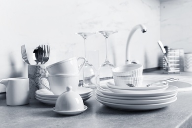 Set of clean dishes and cutlery on kitchen counter