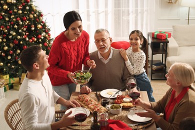 Photo of Happy family enjoying festive dinner at home. Christmas celebration