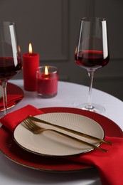 Photo of Place setting with candles on white table. Romantic dinner