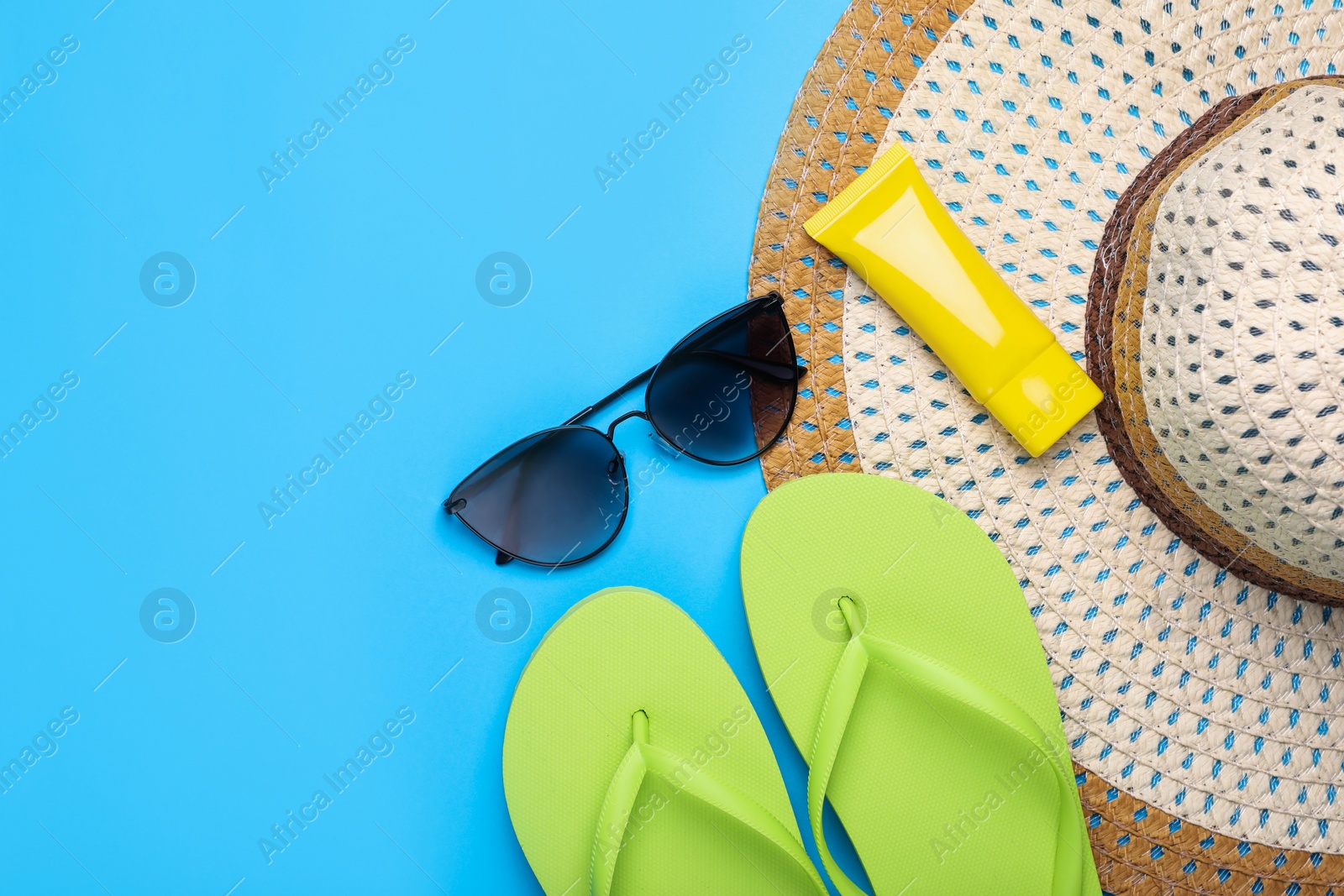Flat lay composition with beach accessories on light blue background, space for text Photo of Flat lay composition with beach accessories on light blue background, space for text