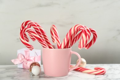 Photo of Candy canes and Christmas balls on white marble table