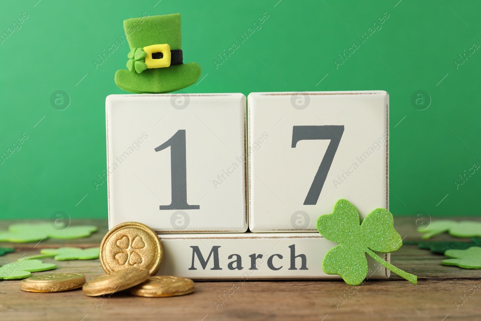 Photo of Composition with block calendar on wooden table. St. Patrick's Day celebration