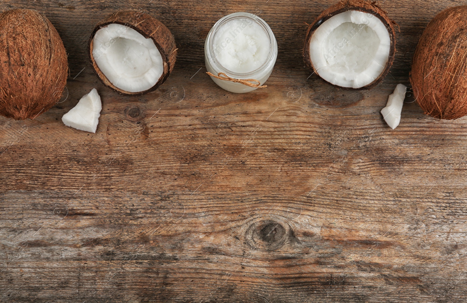 Photo of Flat lay composition with coconut oil on wooden table, space for text. Cooking ingredients