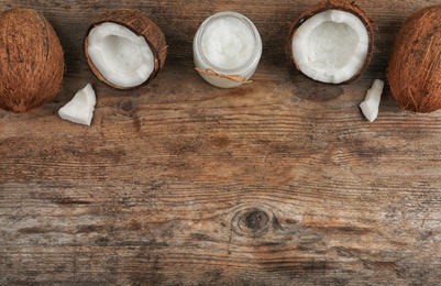 Photo of Flat lay composition with coconut oil on wooden table, space for text. Cooking ingredients