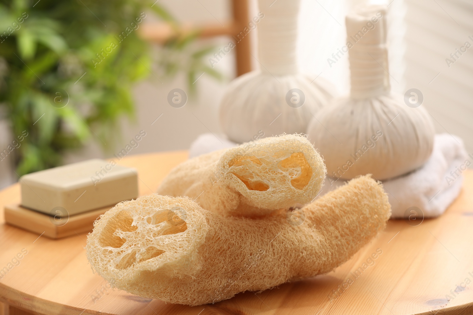 Photo of Loofah sponges on wooden table indoors, closeup