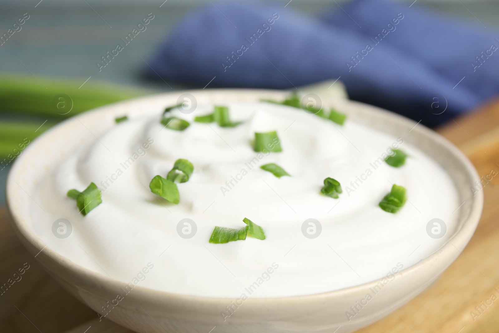 Photo of Fresh sour cream with onion in bowl, closeup