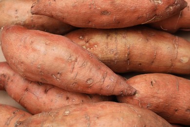 Whole ripe sweet potatoes as background, top view