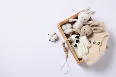 Photo of Different baby accessories and clothes in wooden crate on white background, top view. Space for text