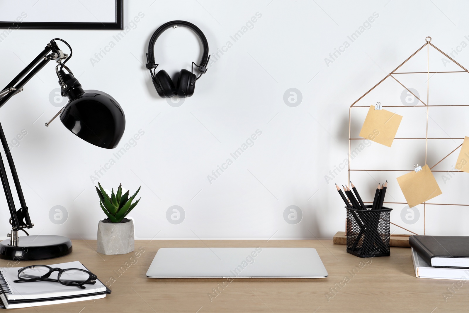 Photo of Home workplace. Laptop, lamp and stationery on wooden desk