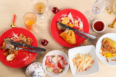 Photo of Flat lay composition of food leftovers after party on wooden table