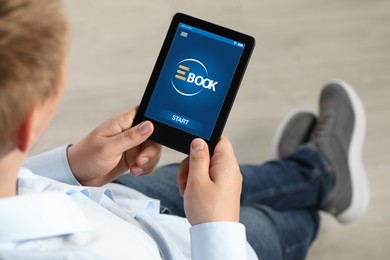 Image of Man reading book in electronic format using e-reader, closeup