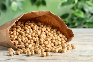 Photo of Raw chickpeas on white wooden table, closeup