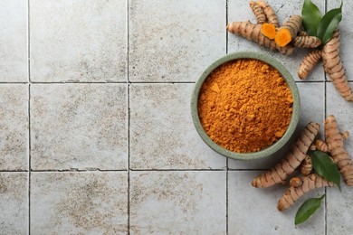Photo of Aromatic turmeric powder, raw roots and leaves on light tiled table, flat lay. Space for text
