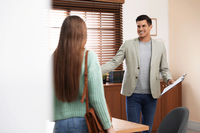 Professional psychotherapist with young woman in office