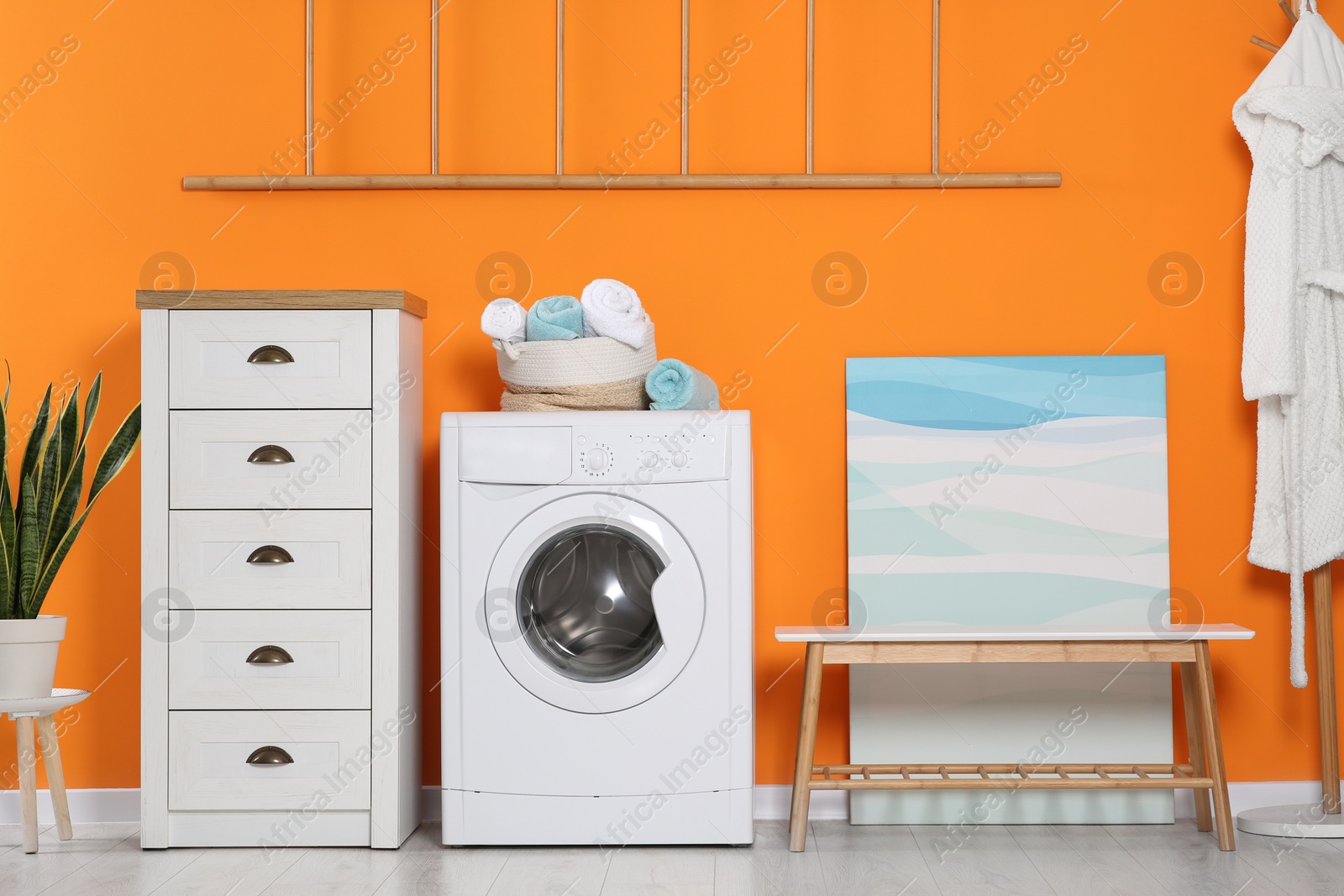 Photo of Stylish laundry room with washing machine. Interior design