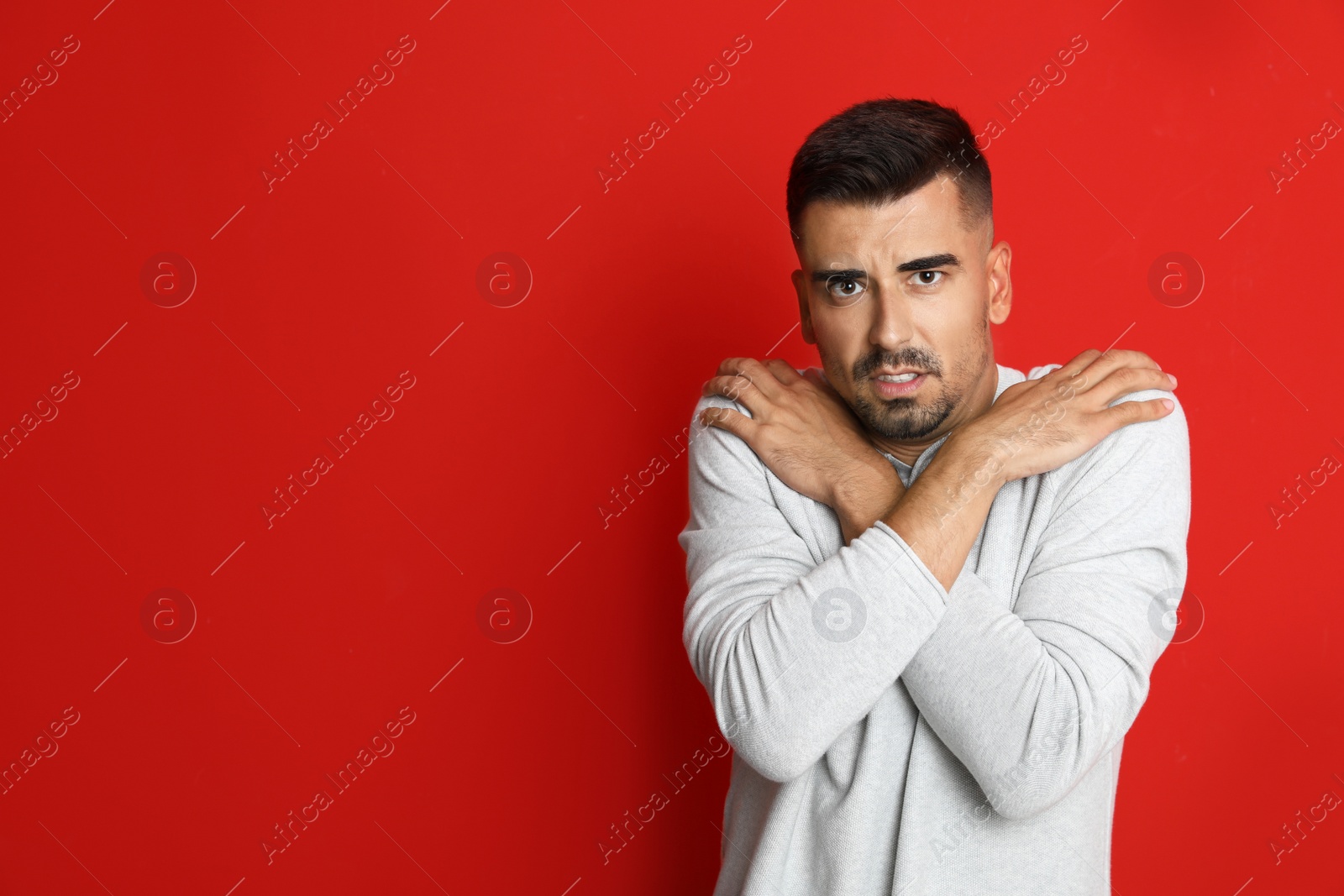 Image of Man suffering from fever on red background, space for text. Cold symptoms