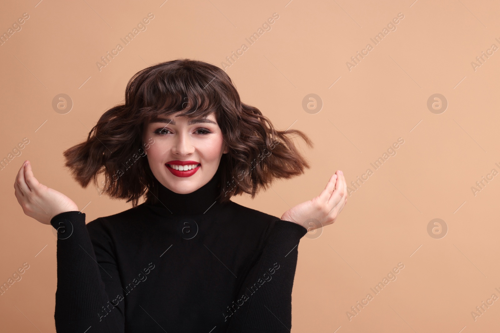 Photo of Portrait of beautiful young woman with wavy hairstyle on beige background. Space for text