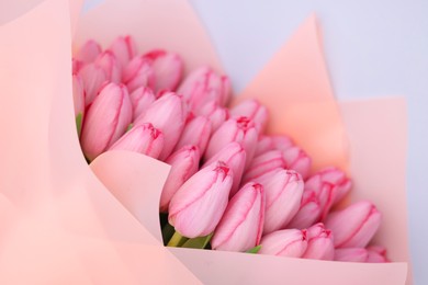Bouquet of beautiful pink tulips on light grey background, above view