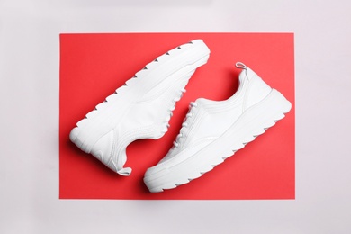 Pair of stylish sneakers on color background, top view