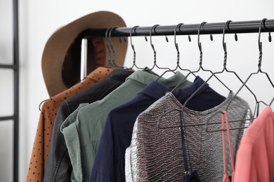 Different stylish clothes on rack in dressing room, closeup