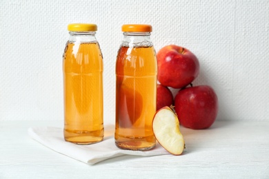 Bottles of apple juice on white table