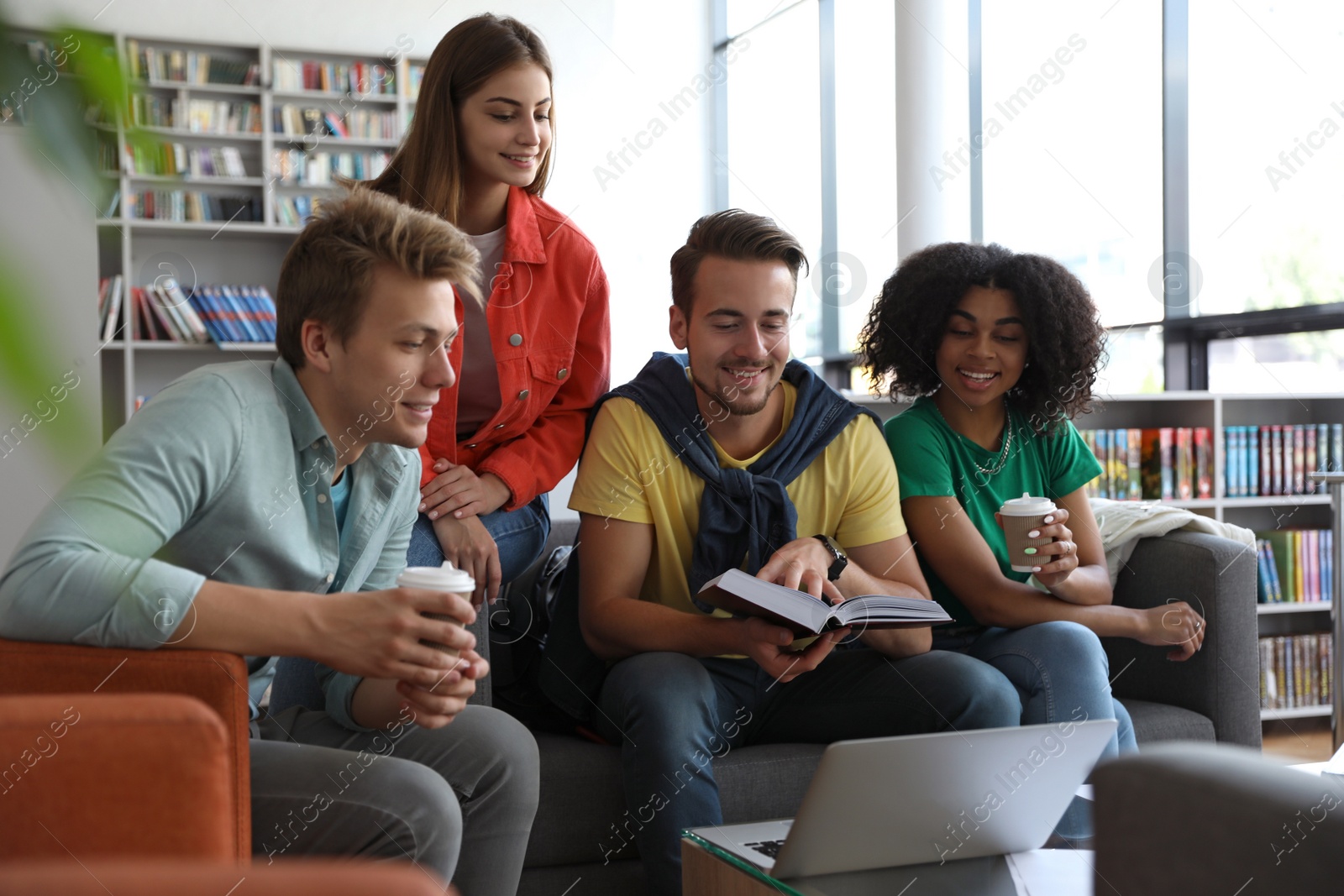 Photo of Group of young people studying at table in library