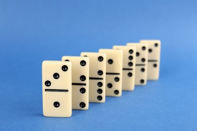 Row of white domino tiles on blue background