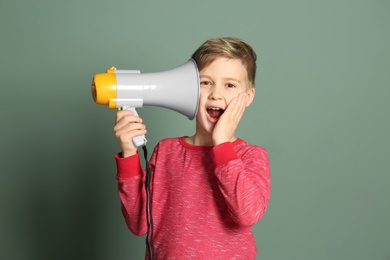 Photo of Cute little boy with megaphone on color background
