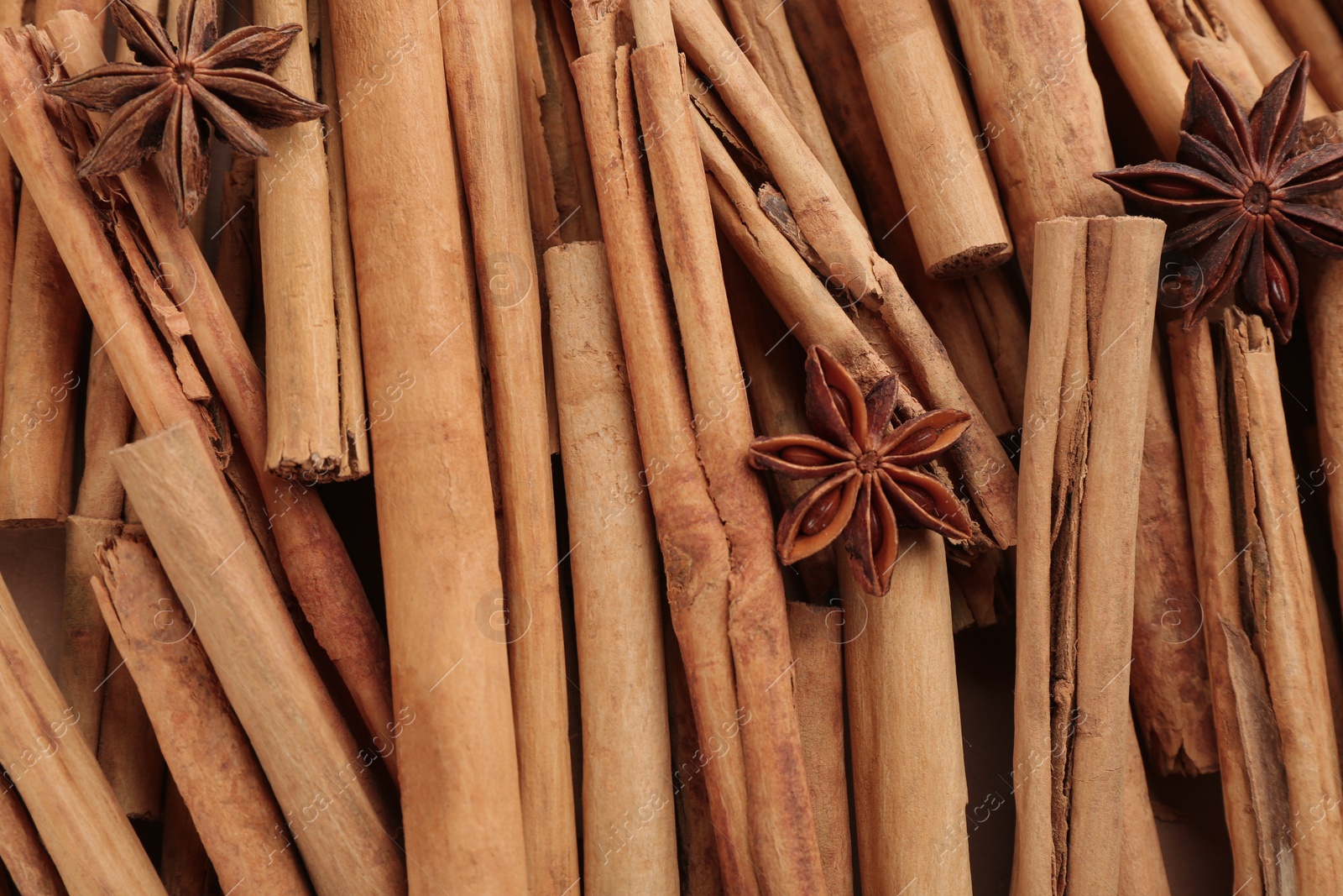 Photo of Aromatic cinnamon sticks and anise as background, top view