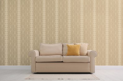 Image of Comfortable beige sofa near wall. Minimalist living room interior