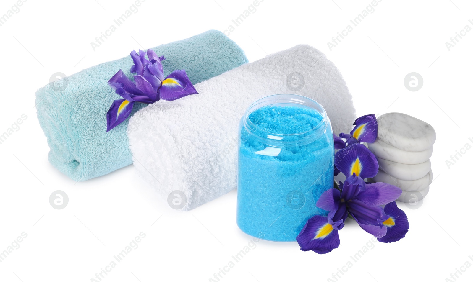 Photo of Glass jar with light blue sea salt, towels and beautiful flowers on white background