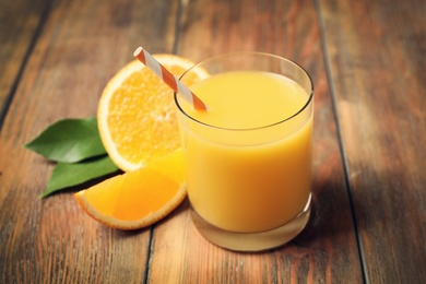 Glass of orange juice and fresh fruits on wooden table, closeup