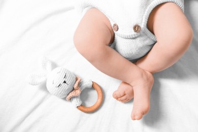 Photo of Newborn baby with toy bunny lying on bed, top view
