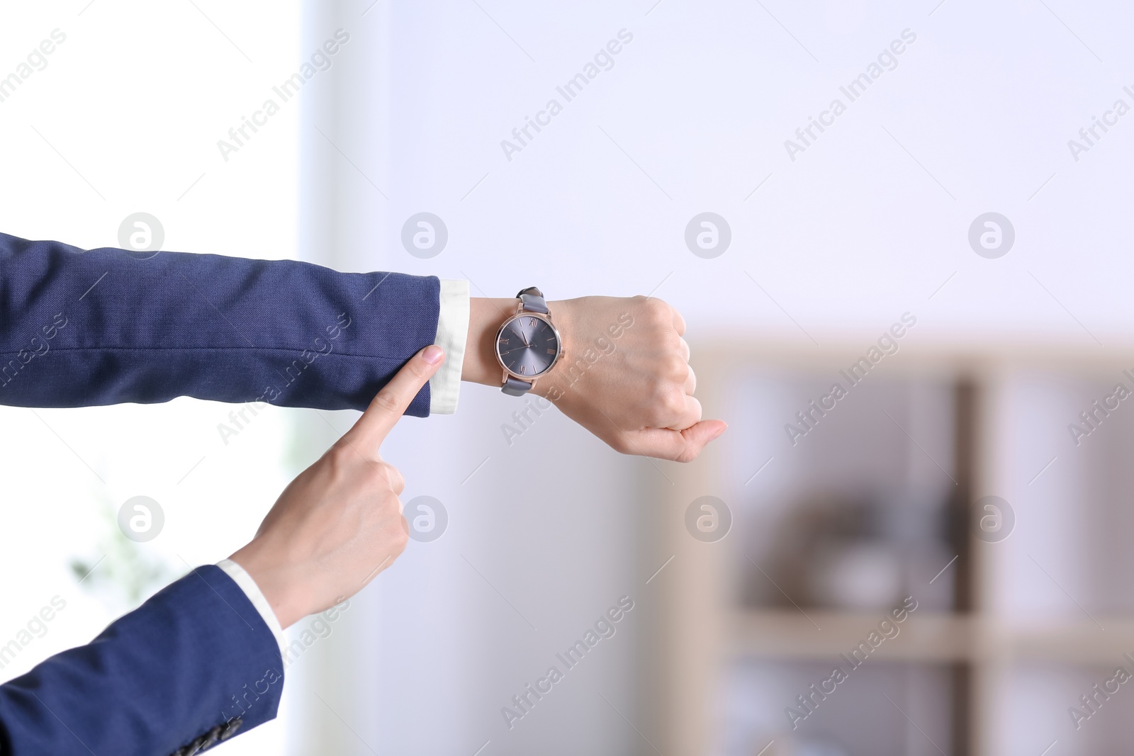 Photo of Businesswoman with wristwatch on blurred background. Time concept